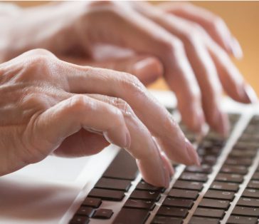 close-up of woman typing on computer