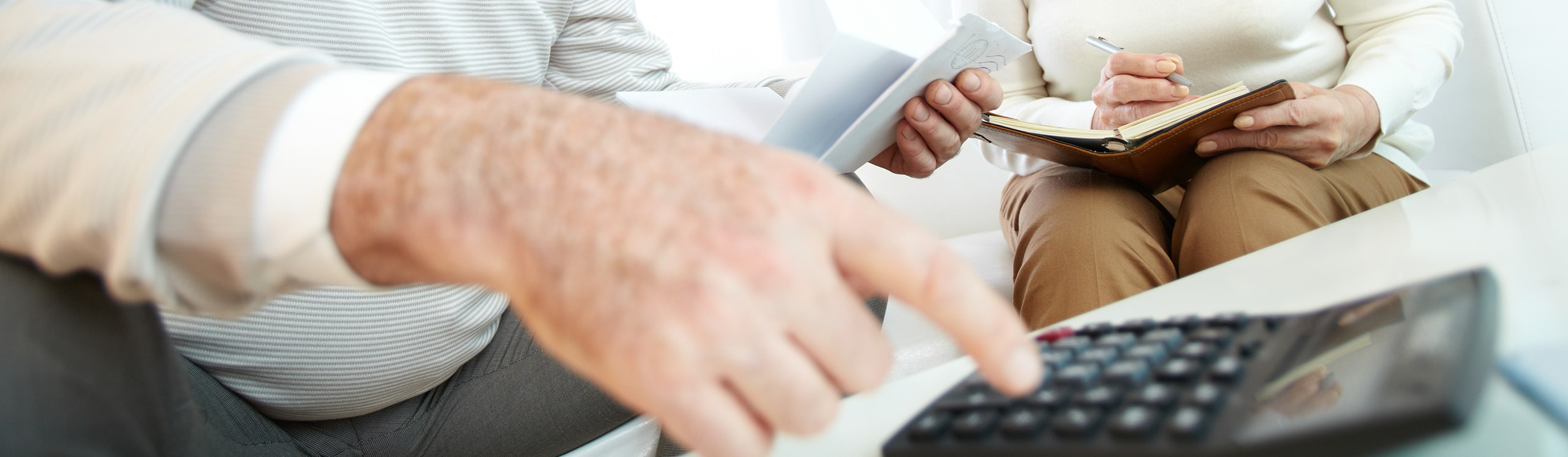 close-up of gentleman using calculator